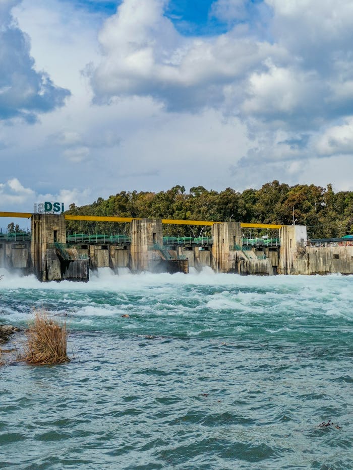 A powerful hydroelectric dam with flowing water under a dramatic cloudy sky, showcasing renewable energy.